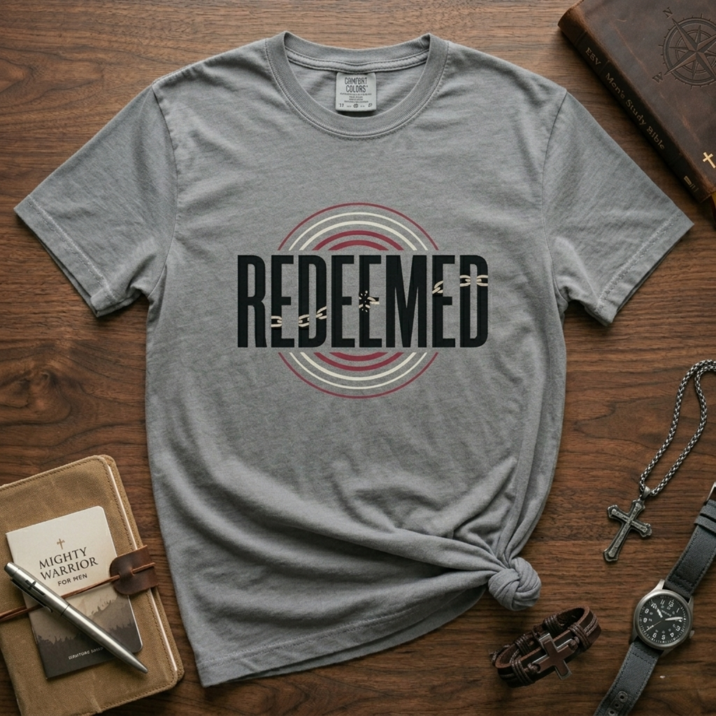 Christian “Redeemed” graphic t-shirt in Solid Athletic Gray, featuring bold typography with broken chain symbolism and circular red and white accent design.