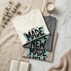 Stack of t-shirts with 'MADE NEW' design on a marble surface with decor items. 'Made new' shirt, Christian graphic tee, Christian shirt women, faith based apparel, Christian boutique clothing. Shirts made by Eternal Thread Apparel, a Christian apparel store.