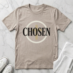 Minimalist Christian “Chosen” graphic t-shirt in Heather Dust beige featuring bold black typography with a modern cross-inspired circular design.