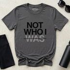 Minimalist Christian t-shirt with “Not Who I Was” redemption message in Asphalt Gray. Modern Christian streetwear t-shirt with testimony inspired message, made by Eternal Thread Apparel, a Christian apparel store.