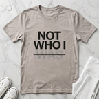 Minimalist Christian t-shirt with “Not Who I Was” redemption message in Heather Dust. Modern Christian streetwear t-shirt with testimony inspired message, made by Eternal Thread Apparel, a Christian apparel store.