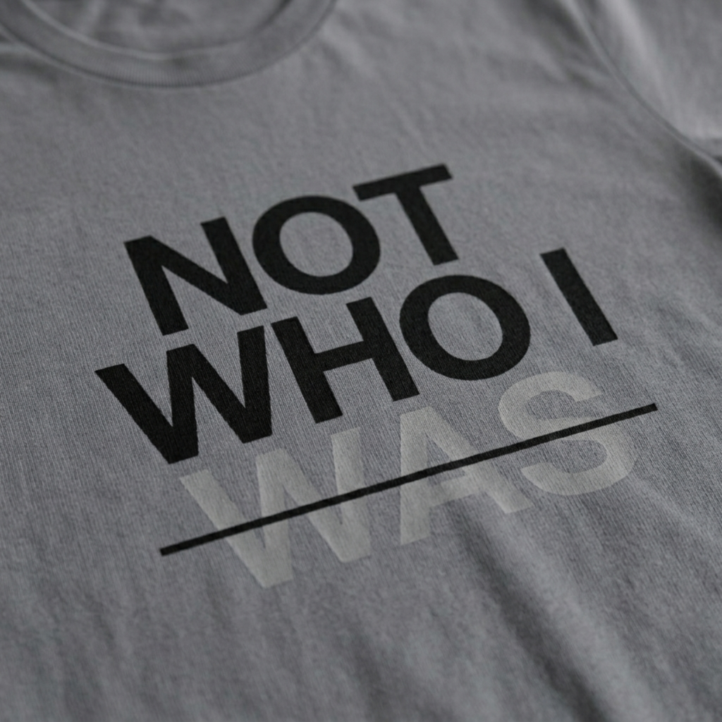 Zoomed in detail shot of the "Not Who I Was" Modern Christian Streetwear t-shirt sold by Eternal Thread Apparel, in Storm Gray and two other colors.