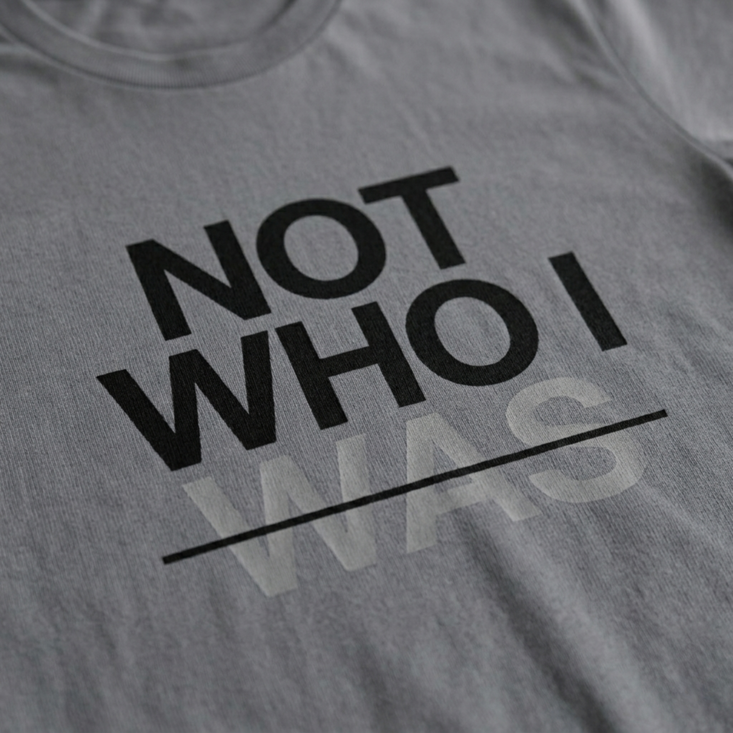 Zoomed in detail shot of the "Not Who I Was" Modern Christian Streetwear t-shirt sold by Eternal Thread Apparel, in Storm Gray and two other colors.